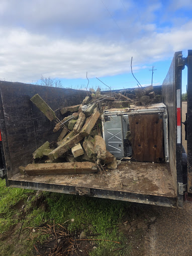 A truck with a pile of wood in the back