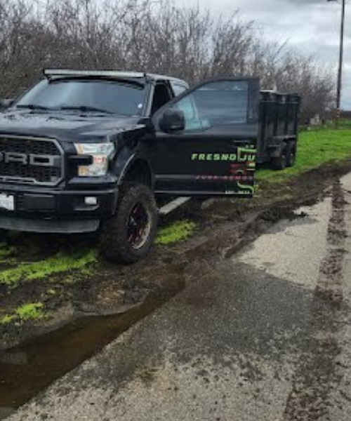 A black truck parked on the side of a road