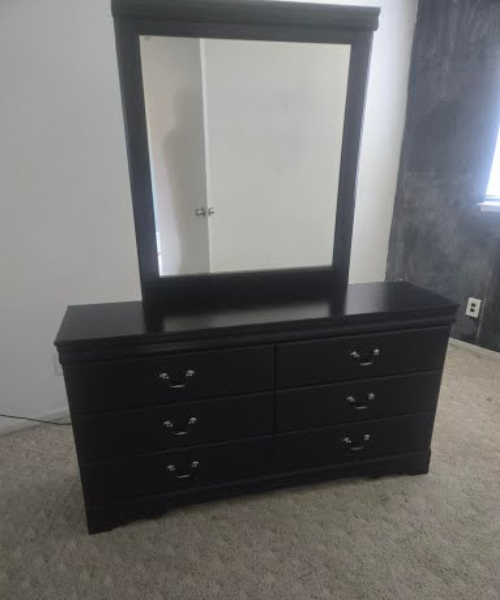 A black dresser with a mirror on top of it