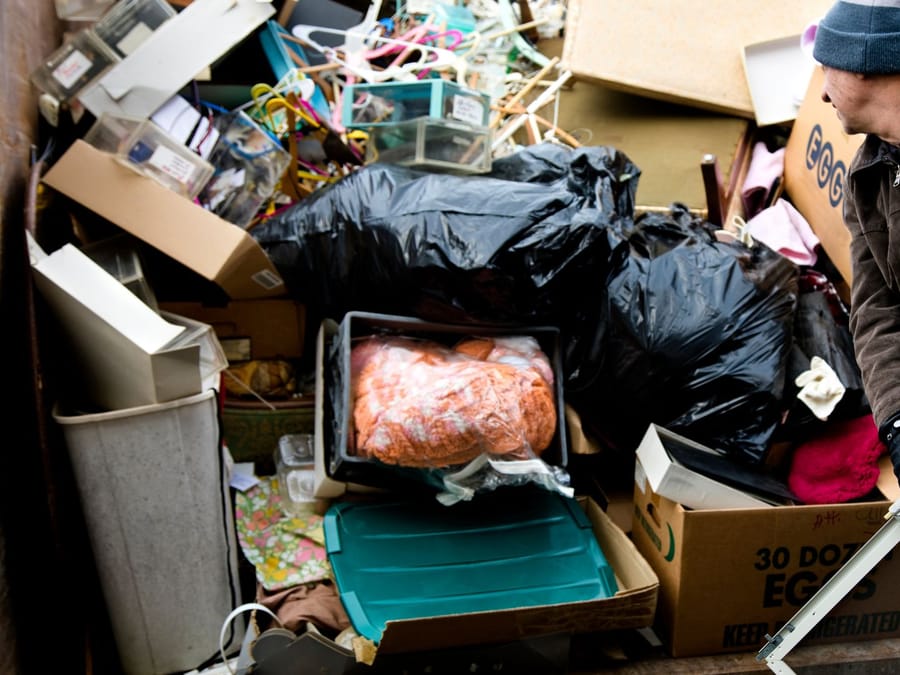 Bagged belongings and debris being cleared from a vacated Fresno rental unit