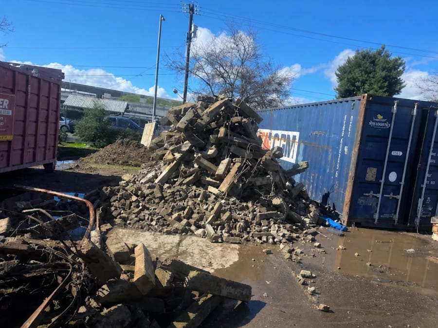 Broken concrete and demolition material staged for hauling after a structure came down