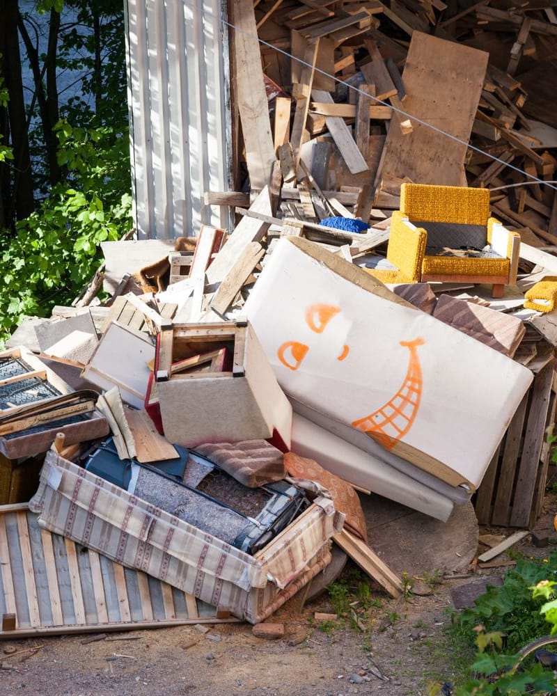 Household junk and building debris piled beside a shed before a Fresno junk removal pickup