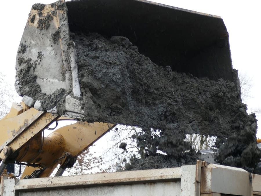 Excavator bucket clearing rubble during a residential demolition in the Central Valley
