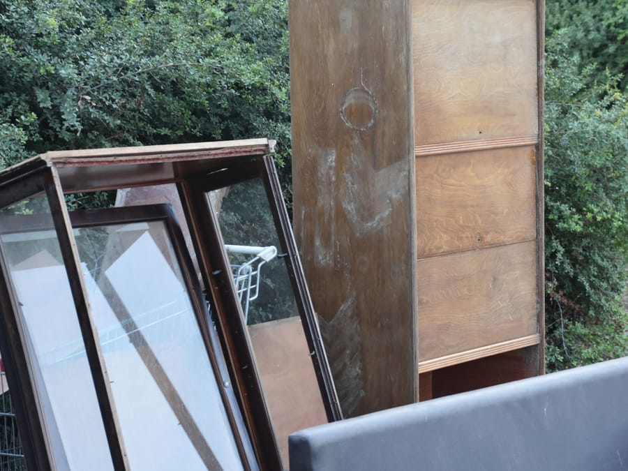 Mattress, cabinet and mirror stacked against a wall before a Fresno bedroom clear-out