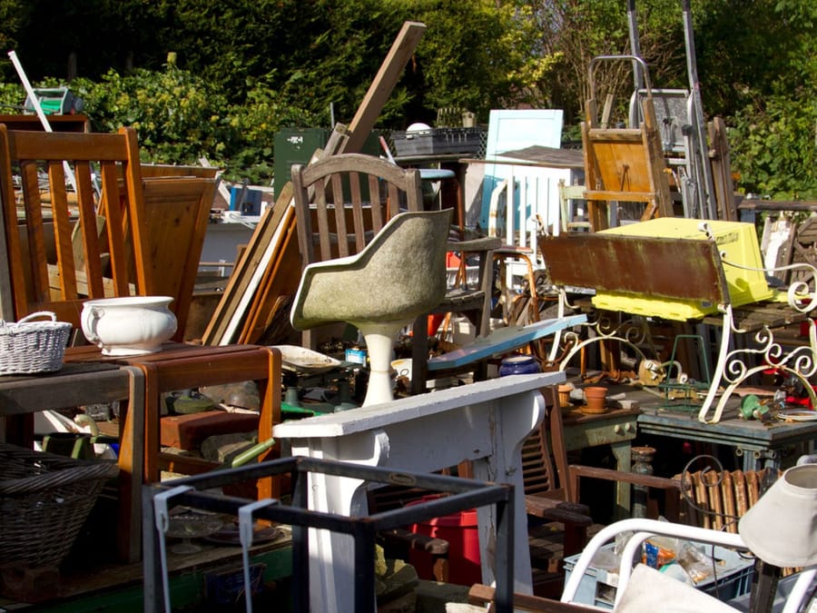 Household furniture staged in a yard while an estate property is cleared