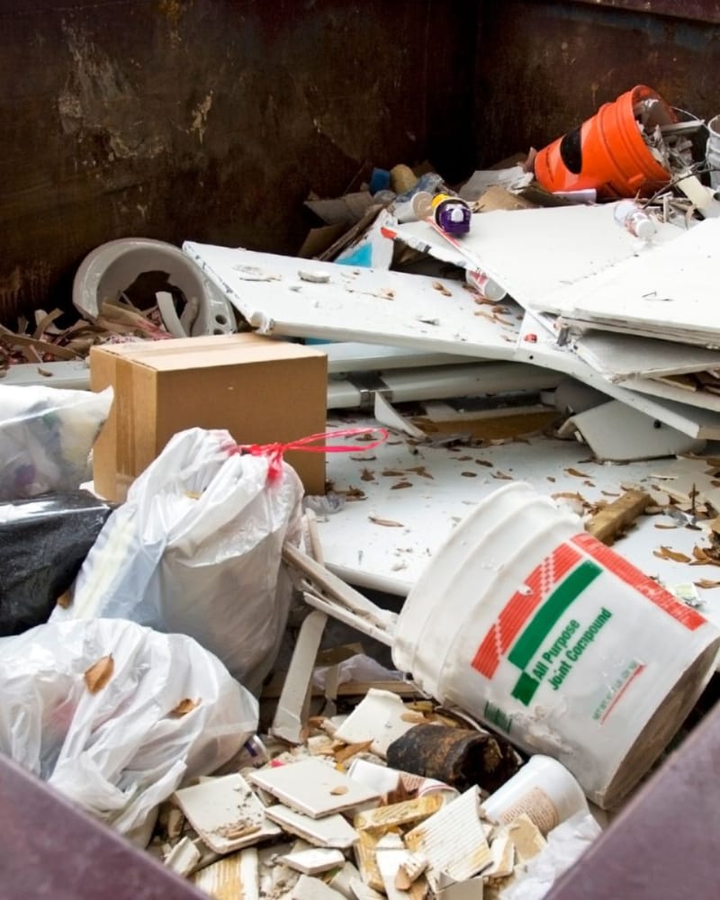 Close-up of drywall offcuts and renovation waste on a Fresno commercial construction site