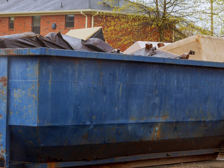 Loaded roll-off dumpster on a Fresno job site, the main alternative to a junk removal service