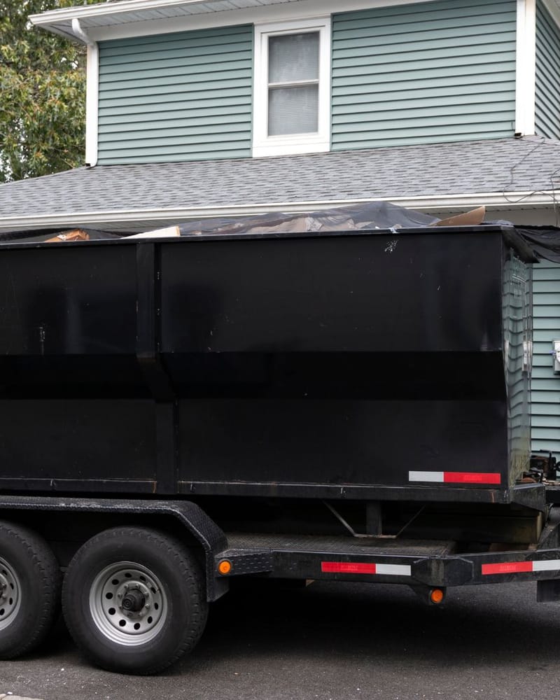 Dump trailer positioned beside a Fresno home ready to receive a dismantled hot tub